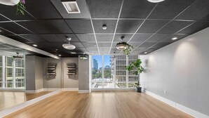 A spacious room with a wooden floor, large windows, and a view of a cityscape. - Chique Loft 10 Min from NYC with Gym, Pool, Sauna (Jersey City)