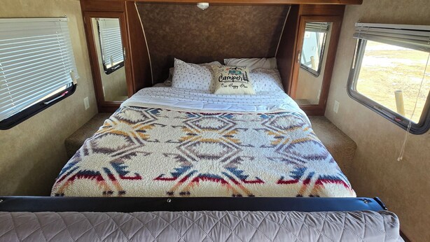 A compact RV bedroom with a bunk bed, a window with blinds, a skylight, and a patterned bedspread. - Private space in a quiet area, great place to disconnect. (East Wenatchee)