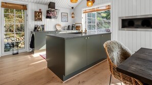 Una cocina moderna con una isla central, suelo de madera y vistas al exterior.