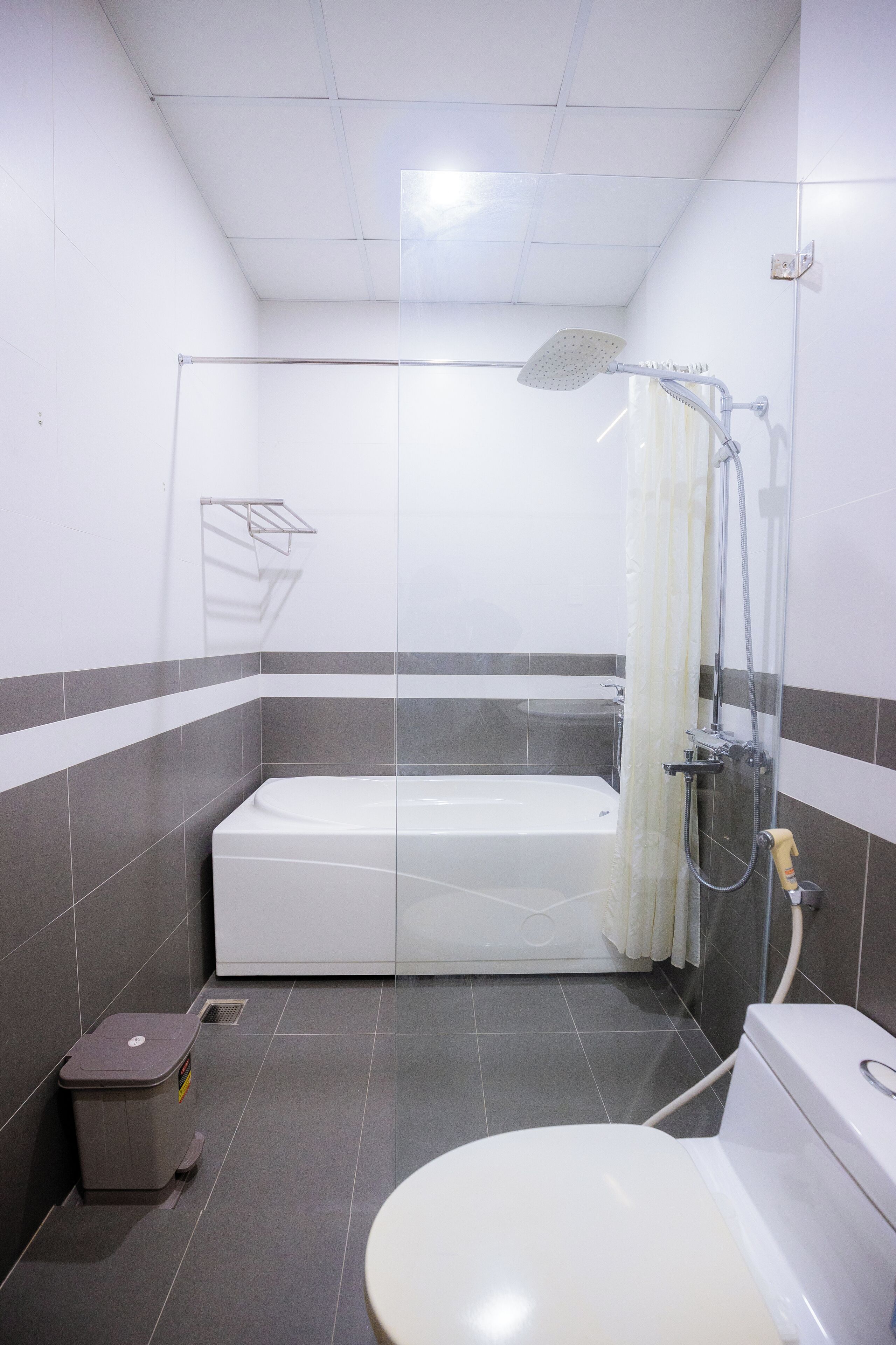 A small bathroom with a bathtub, toilet, and shower.