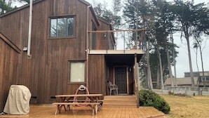 A wooden cabin with a deck, a covered picnic table, and a small outdoor seating area. - Ocean View, Cozy 2-bedroom cabin in tranquil Gualala with WiFi and huge firepit (gualala)