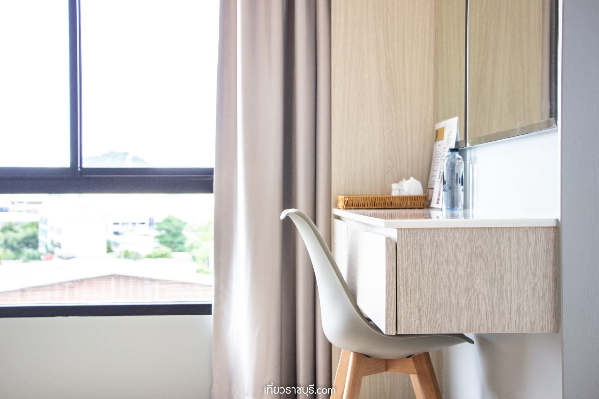 A modern bathroom with a wooden vanity, a mirror, and a window with curtains.