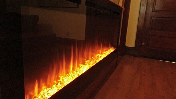 A room with a long, narrow fireplace with a fire burning inside. -   Escape to Romance and Luxury (Hot Springs)