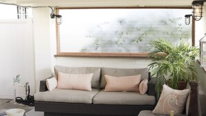 A modern living room with a sofa, a coffee table, and a potted plant.