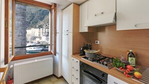 A kitchen with a view of a mountain, a stove, a sink, and cabinets. - The Harbor Old House, Riva del Garda, Italy (Riva del Garda)