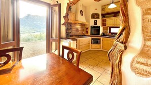 Una cocina con armarios de madera, una mesa de comedor y vistas al exterior.