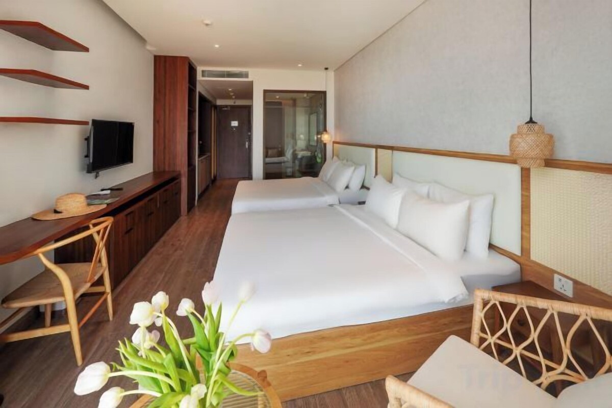 Une chambre d’hôtel avec un grand lit, un bureau et une télévision.