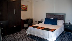 A hotel room with a large bed, a desk, and a wardrobe. - Enjoyable 2-bedroom apartment with WiFi in Uyuni (Uyuni)
