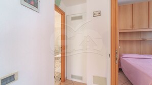 Une chambre à coucher avec un lit, des armoires en bois et une porte donnant sur une autre pièce.
