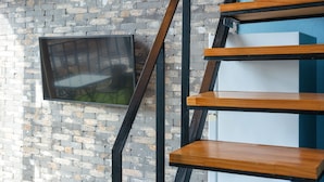 A staircase with wooden steps and black metal railings against a brick wall. - Yeosu Island Pet Pension (Yeosu)
