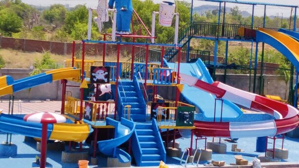 Parque acuático con toboganes, una estructura para escalar y una zona de piscina.