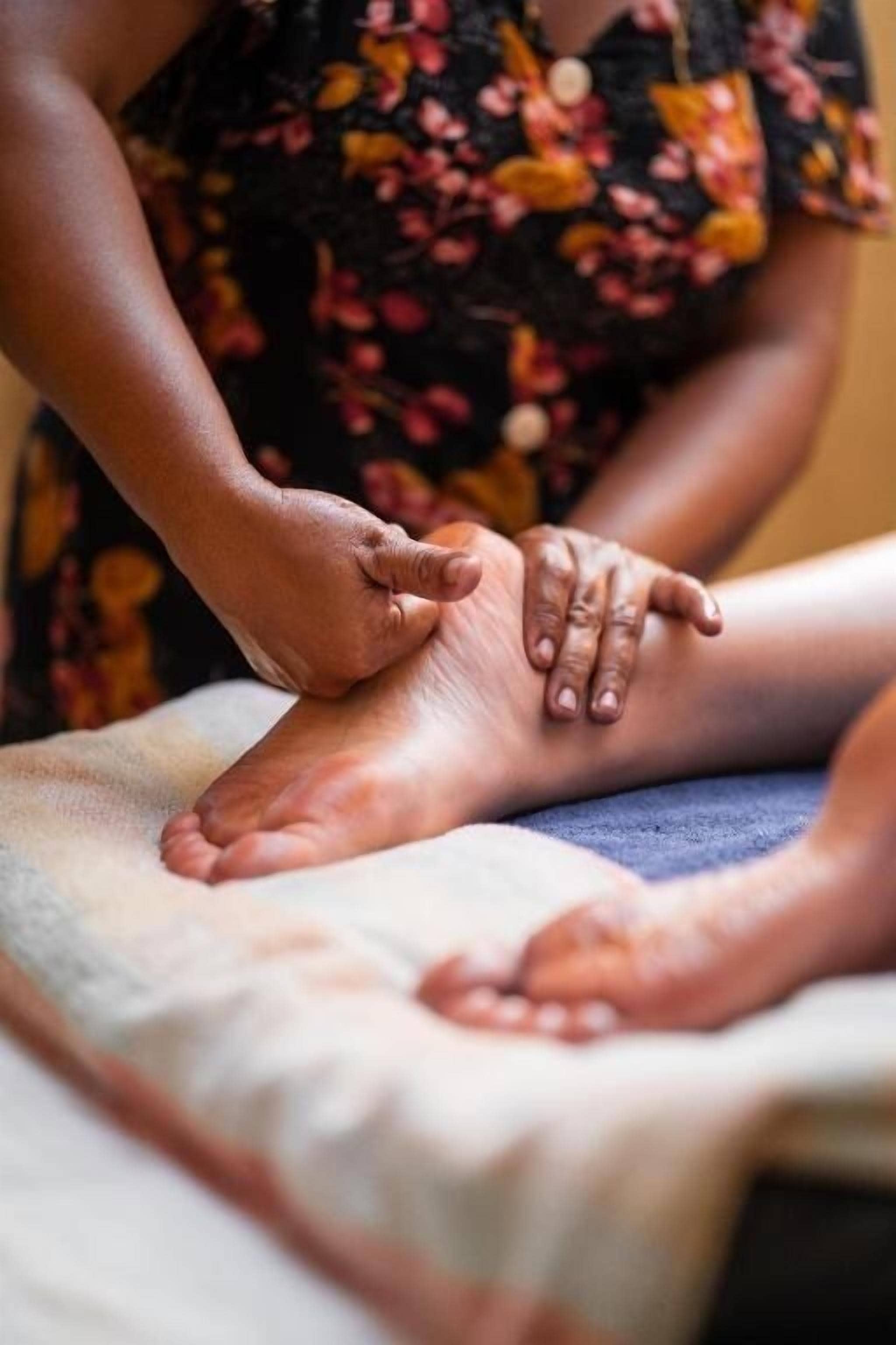 A foot massage being performed on a massage table.