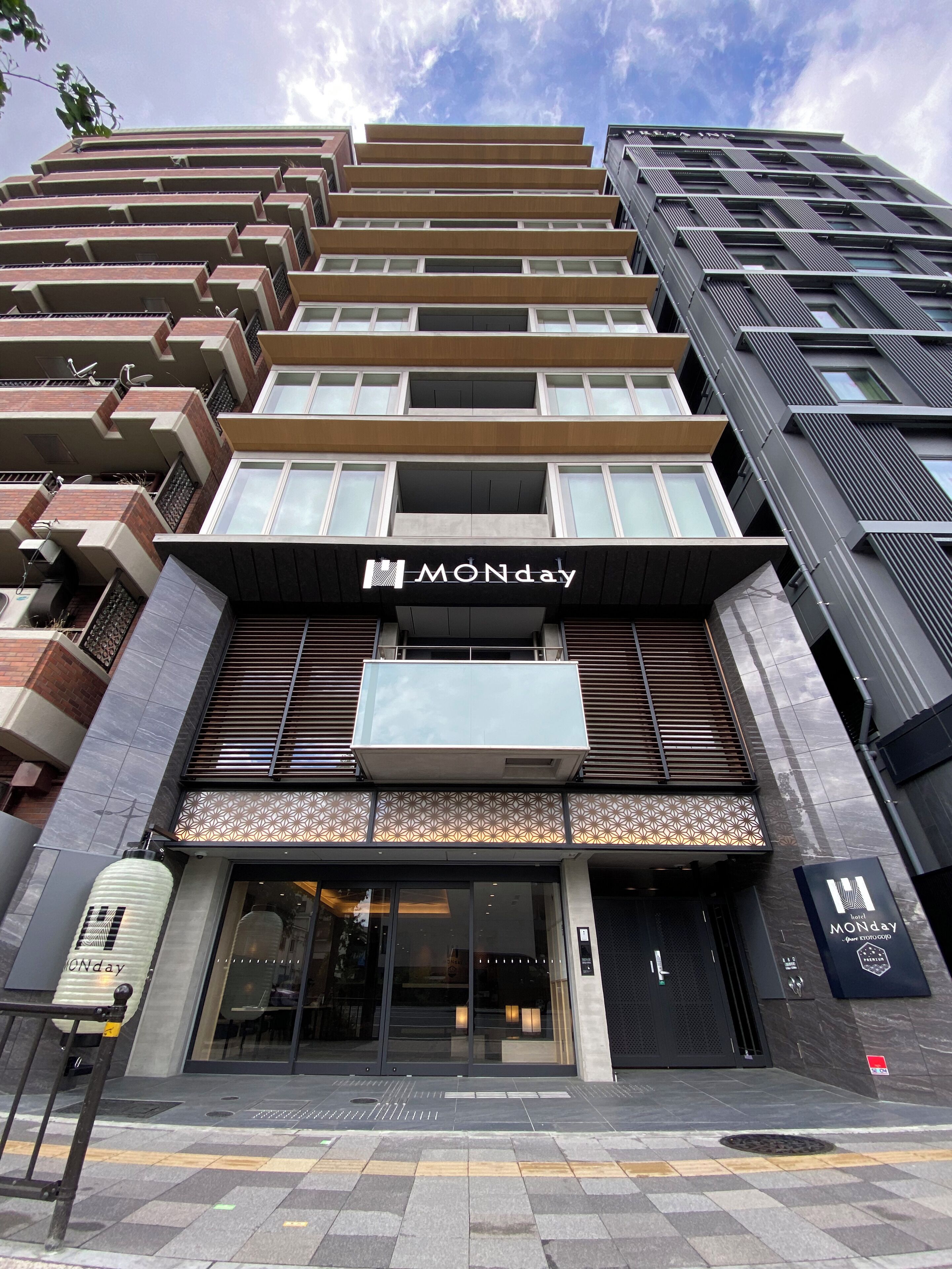 Un hôtel à la façade moderne, doté de nombreux balcons et d’une enseigne bien visible indiquant « MONday ».