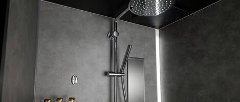 Une douche moderne dotée d’un pommeau de douche à main et d’un panneau de commande fixé au mur.