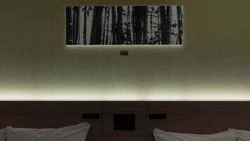 A hotel room with a wall-mounted artwork depicting a forest scene, a bed with white linens, and a wooden headboard.