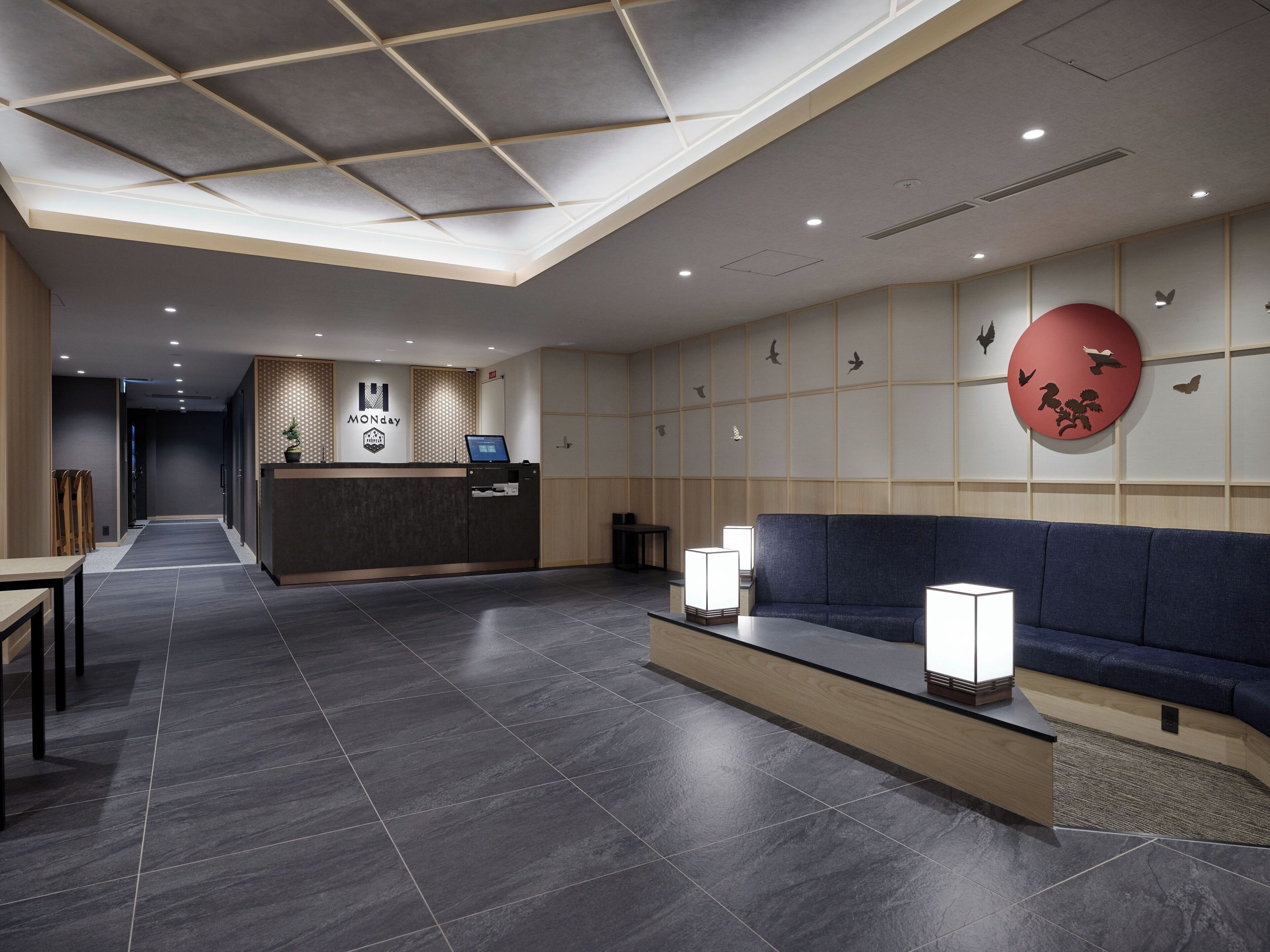 A modern reception area with a reception desk, seating area, and a wall with bird motifs.