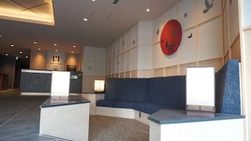 A reception area with a blue sofa, a reception desk, and a wall with bird silhouettes.