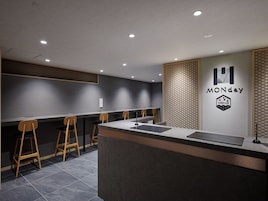 A modern reception desk with a logo, a counter, and bar stools.