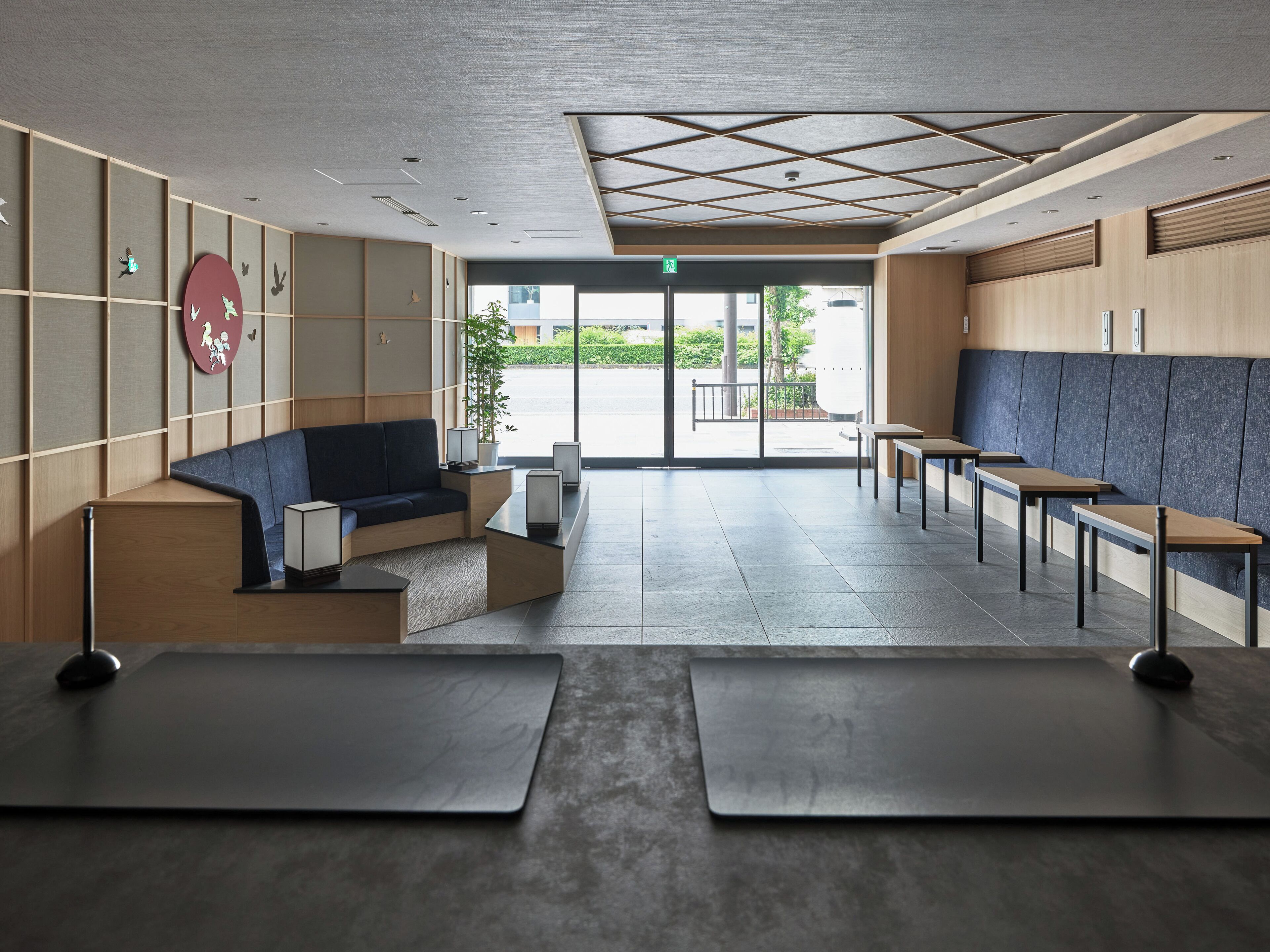 A modern waiting area with a sofa, tables, and a view of the outside.