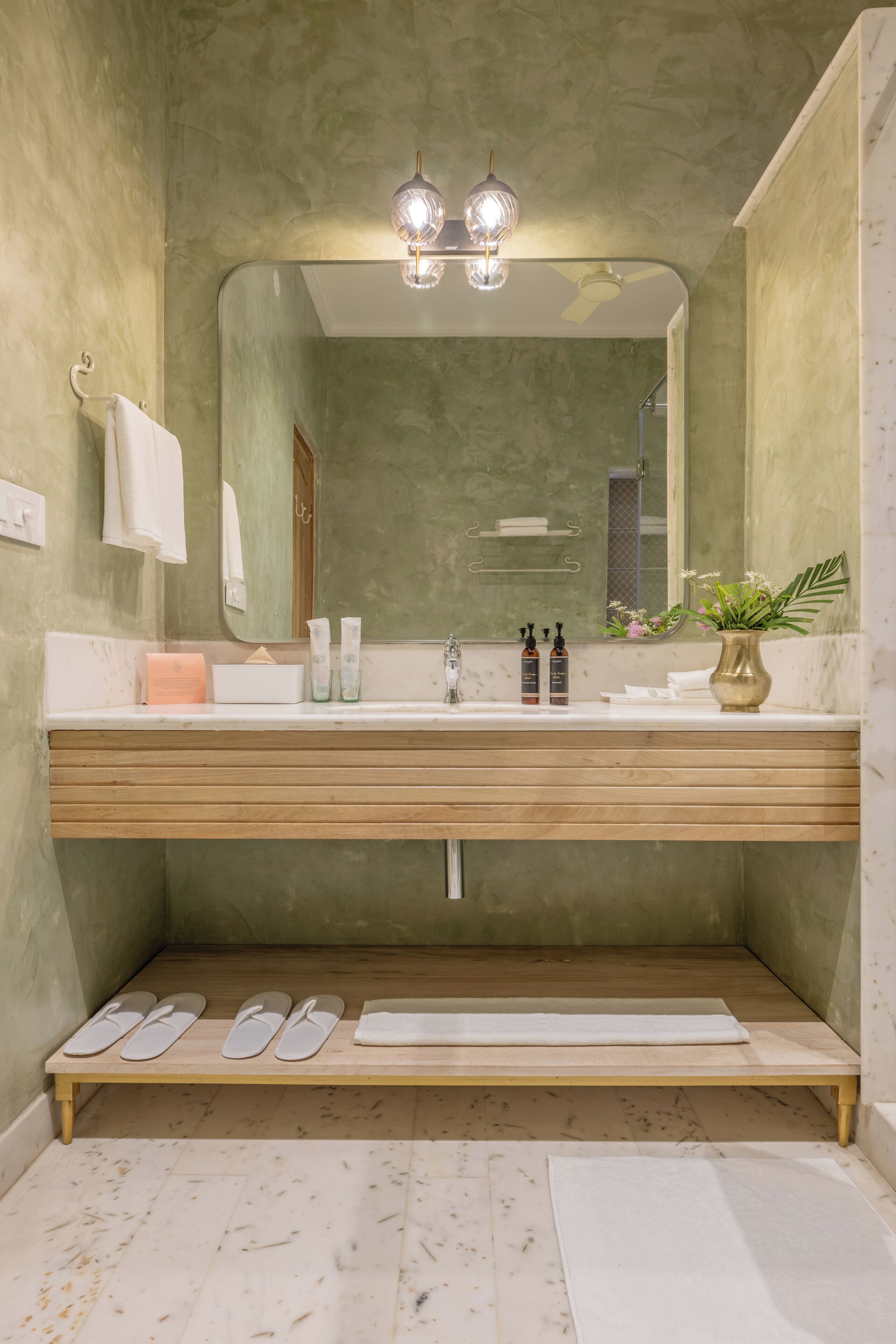 A bathroom with a wooden vanity, a mirror, and a sink.