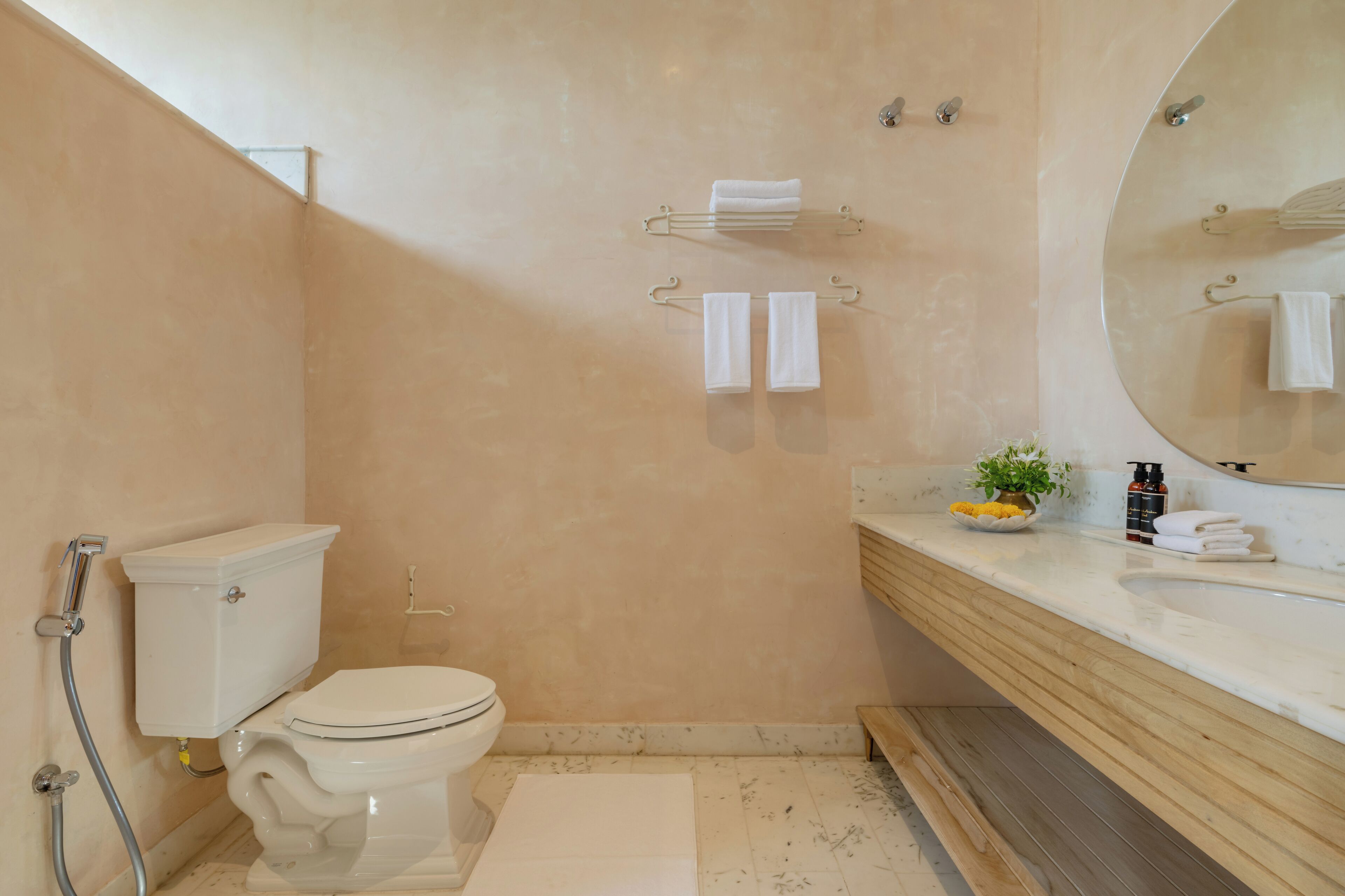 A bathroom with a toilet, a sink, a mirror, and a shower.