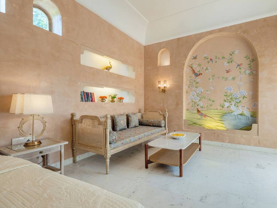 A spacious room with a sofa, a small table, and a decorative wall mural.