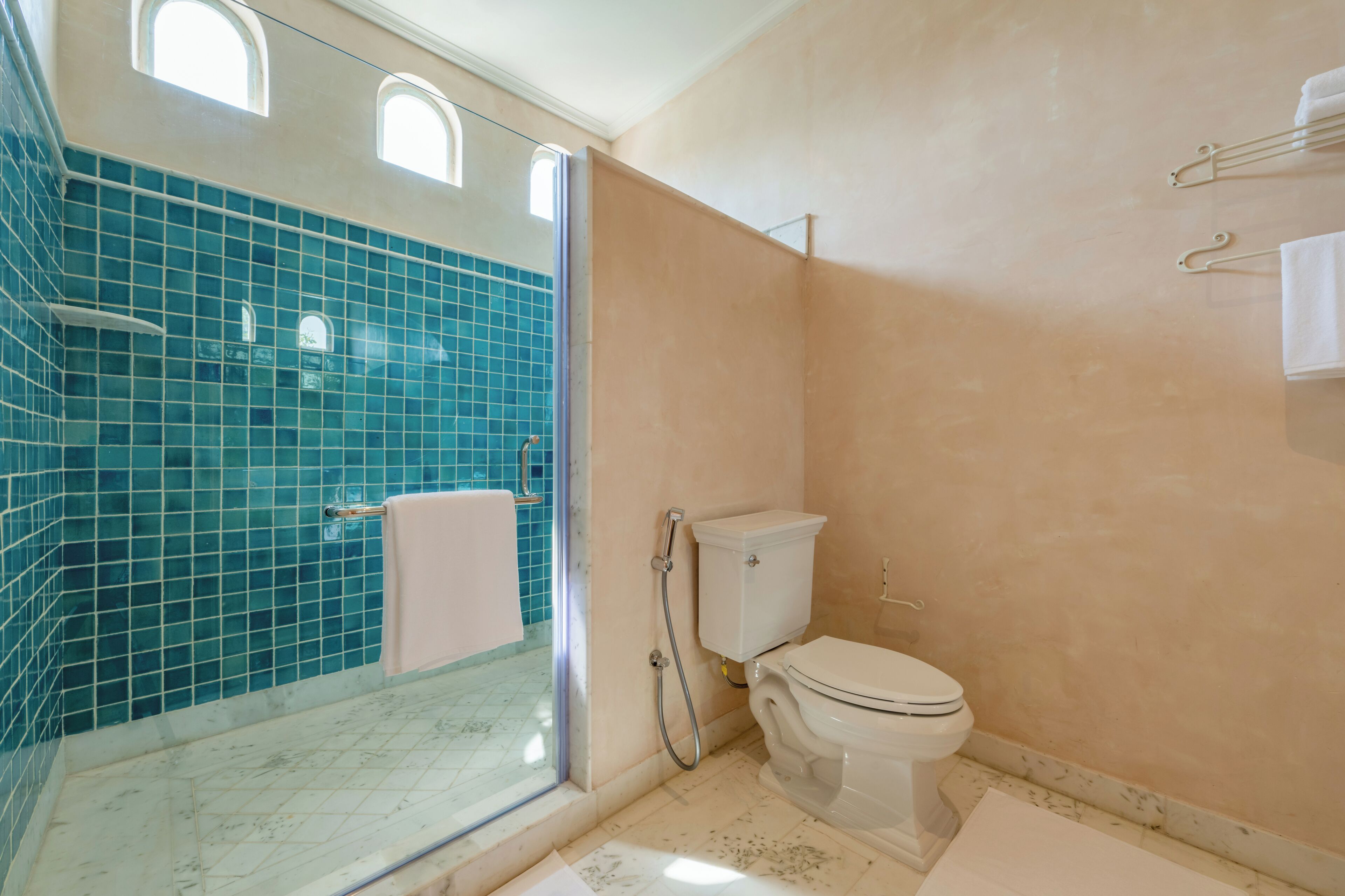Un baño con cabina de ducha de vidrio, inodoro y lavamanos.