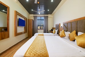 A hotel room with two beds, a ceiling fan, a TV, and a window with curtains. - Hotel BKC Minerva (Mumbai)
