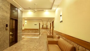 A hotel lobby with a marble floor, a reception desk, a sofa, and a staircase. - Hotel BKC Minerva  (Mumbai)