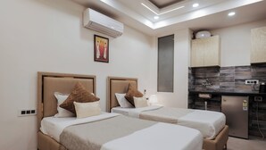 Une chambre d’hôtel avec deux lits, une kitchenette et un appareil de climatisation.