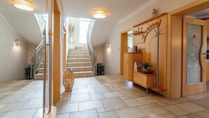 Un hall d’entrée spacieux avec un escalier menant à une chambre à coucher située en mezzanine.
