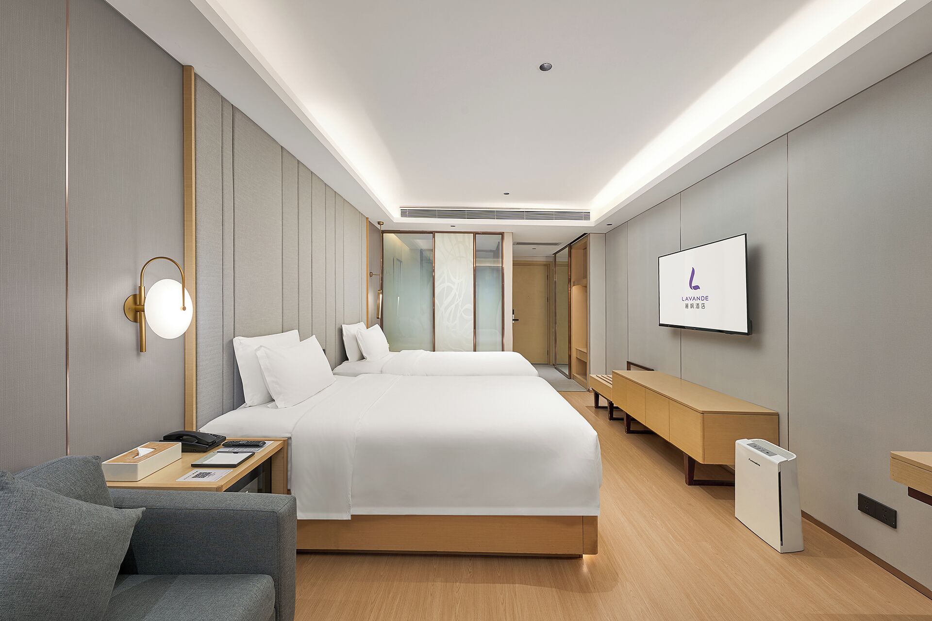 A modern hotel room with a large bed, a desk with a chair, a flat-screen TV, and a built-in heater.