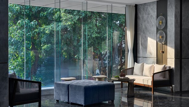 A modern interior with a large glass window, a sofa, a chair, and a small table. - Lavande Hotel Guangzhou Beijing Road Pedestrian Street Haizhu Square Metro Station Branch - Free Deliver Service to Canton Fair Complex During Canton Fair Period (Guangzhou)