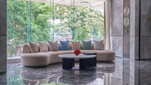 A modern lobby with a sectional sofa, a round coffee table, and a large window offering a view of greenery outside. - Lavande Hotel Guangzhou Beijing Road Pedestrian Street Haizhu Square Metro Station Branch - Free Deliver Service to Canton Fair Complex During Canton Fair Period (Guangzhou)