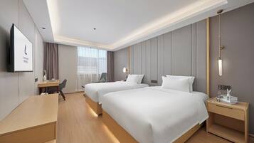 Ein Hotelzimmer mit zwei Betten, einem Schreibtisch, einem Stuhl, einem Fernseher und einem Fenster mit Vorhängen.