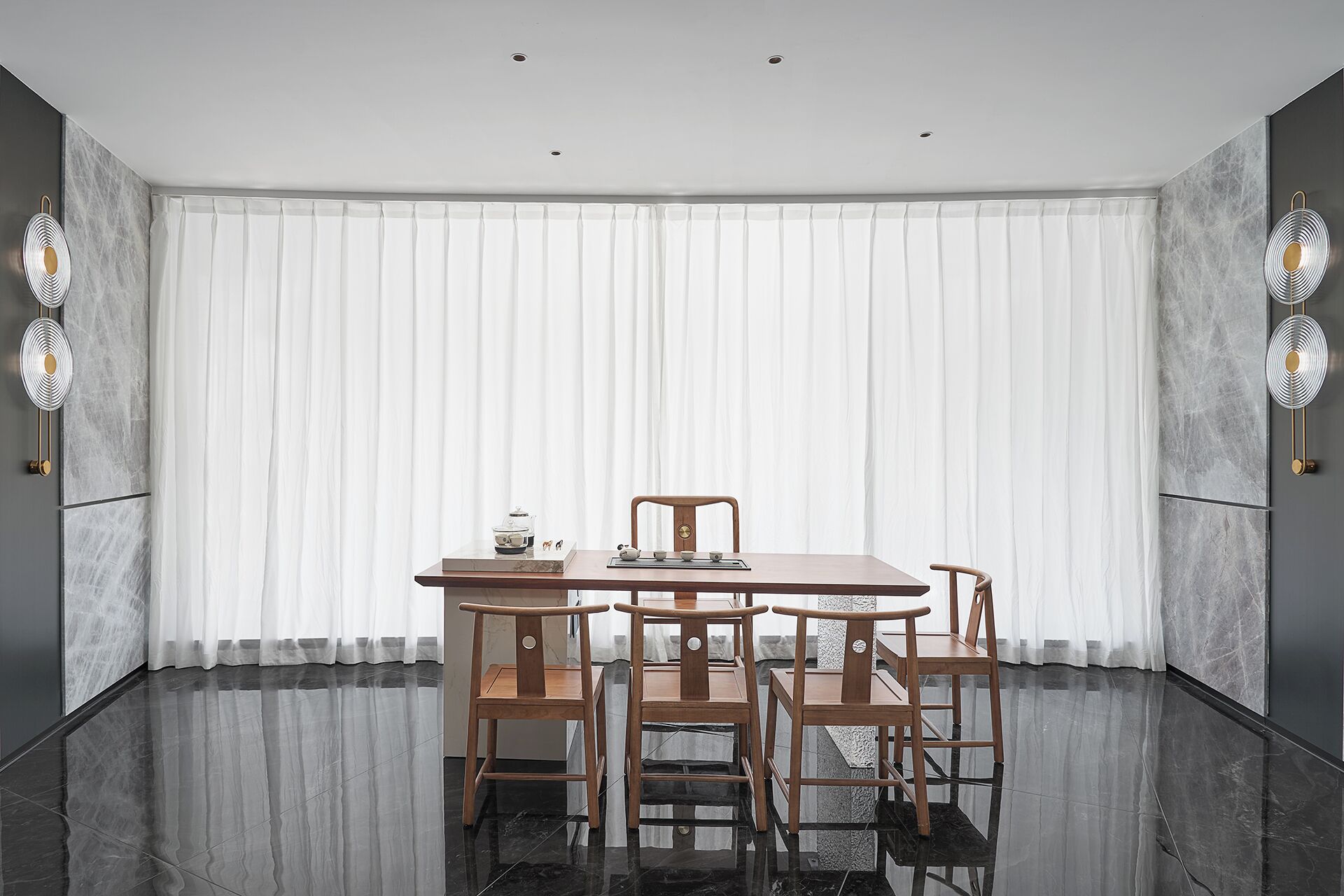 Uma sala de jantar moderna com uma mesa redonda, quatro cadeiras de madeira e um painel de cortina branca.