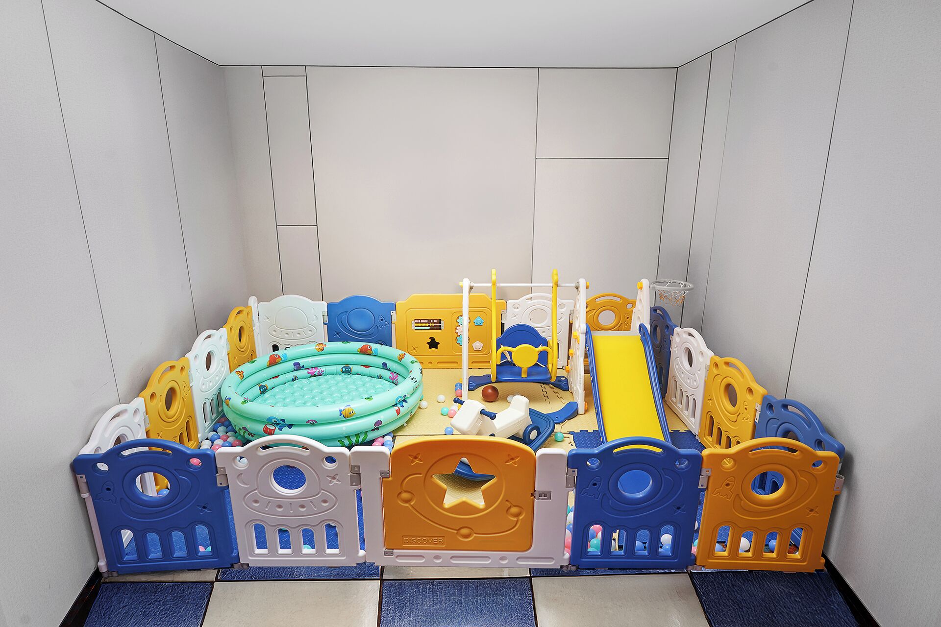 A play area with a pool, inflatable toys, and safety gates.
