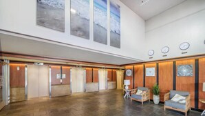 A spacious lobby with a high ceiling, wooden paneling, and a large open area with a patterned rug. - 23 FL-Cozy & Elegant King Studio (Honolulu)