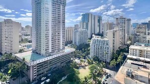 A high-rise building with a modern architectural design, surrounded by other high-rise buildings in an urban setting. - 23 FL-Cozy & Elegant King Studio (Honolulu)