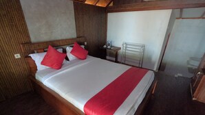 A neatly made bed with white and red bedding, wooden headboard, and a wooden floor. - Maryan Moyo Bungalows and resto (Moyo)