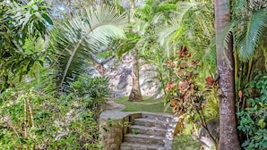 Una escalera de piedra rodeada de exuberante follaje y plantas tropicales.