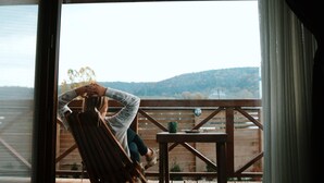 A room with a large window overlooking a wooden deck. - Abant Cozy Homes (Bolu)