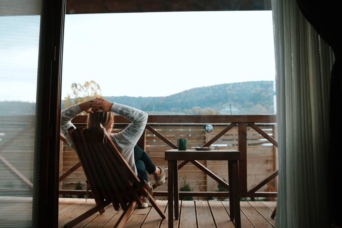 Una habitación con un ventanal grande con vistas a una terraza de madera.