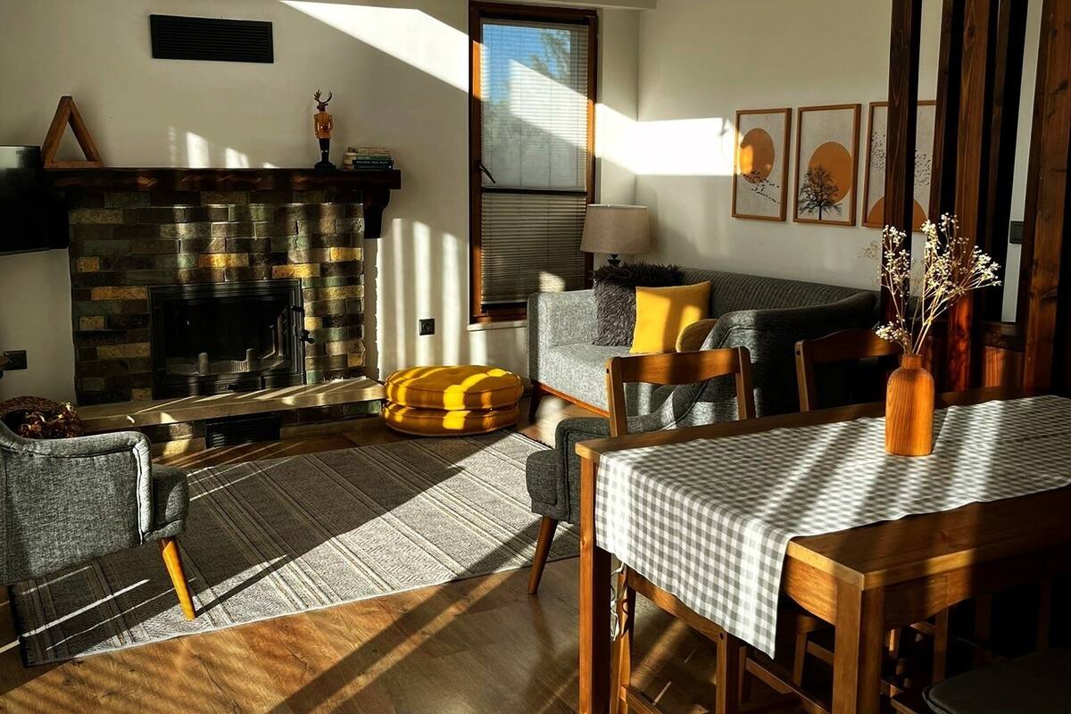 Una sala de estar acogedora con chimenea, una mesa de comedor y un sofá.