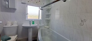 Une salle de bain avec des toilettes, un lavabo et une baignoire.