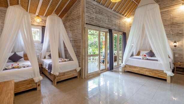 A room with two beds, each with a canopy, wooden flooring, and a view of the outdoors. - Le Biu Garden View (Lembongan Island)