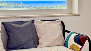 A bed with a view of the sea through a window. - Residence Sole - Apartment 2 (Tertenia)