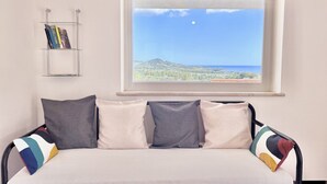 A bed with a view of a landscape through a window. - Residence Sole - Apartment 2 (Tertenia)