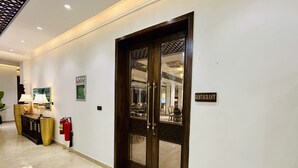 Een hotel lobby met een houten deur waarop 