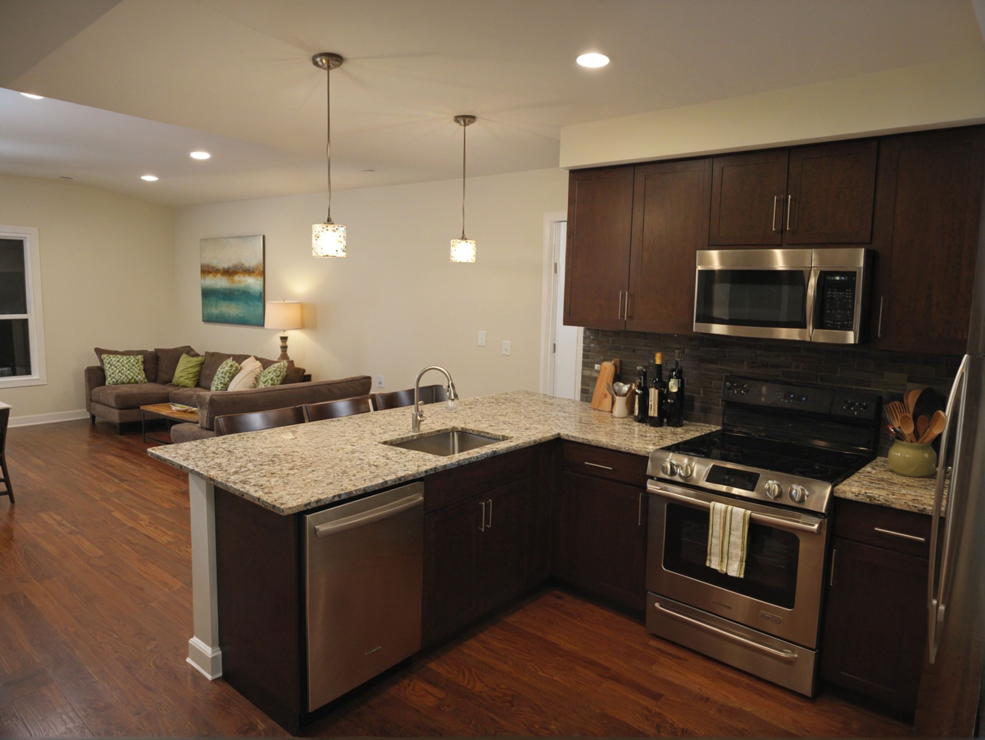 A modern kitchen with dark wood cabinets, stainless steel appliances, granite countertops, and pendant lighting.
